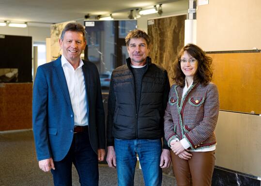 Norbert Peter (l.), Prokurist der Karl Bachl Betonwerke GmbH & Co. KG, begrüßt Rudolf und Elisabeth Kainz, und damit auch das gleichnamige Natursteinwerk, in der Unternehmensgruppe BACHL. (Foto: König/BACHL)